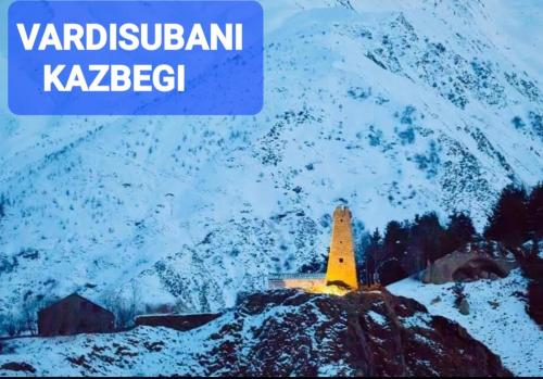 a lighthouse on top of a snow covered mountain at Guest house Track Kazbegi in Kazbegi