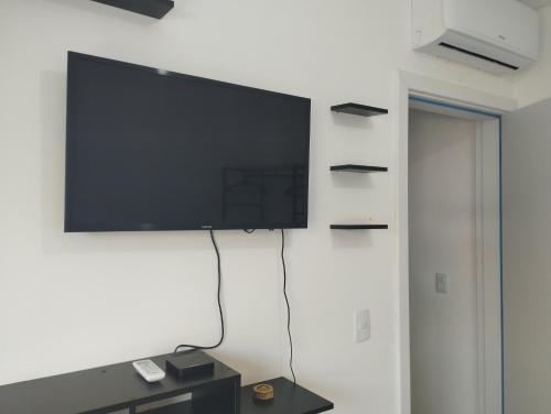 TV de pantalla plana colgada en la pared en Espaço II FLAT, en Florianópolis