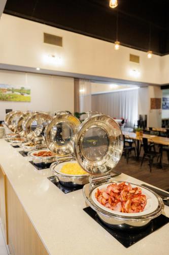 a buffet line with plates of food on a counter at Mercure Kakadu Crocodile in Jabiru