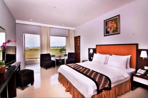 una camera con letto e balcone di Parkside Mandarin Hotel Pekalongan a Pekalongan