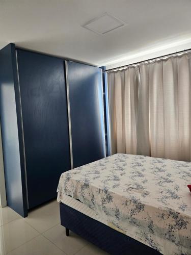 a bedroom with a bed and a blue cabinet at Apartamento 01 in Itapema