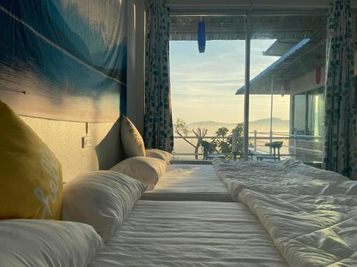 a large bed in a room with a large window at ภูม่านหมอก เขาค้อ in Ban Khao Ya Nua