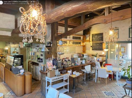 a shop with a chandelier and tables and chairs at Casa Allegra in Yamanakako
