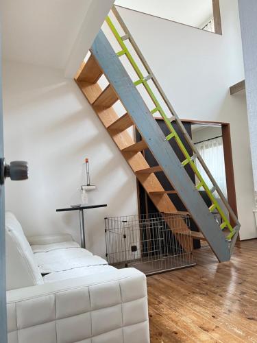 a living room with a white couch and a staircase at Casa Allegra in Yamanakako