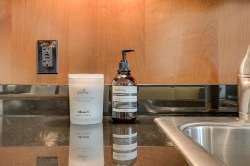 a bottle of mouthwash and a bottle of moisturizers next to a sink at Jewel Suite w/balcony MGM SIGNATURE * 23rd FLOOR* STRIP VIEW in Las Vegas