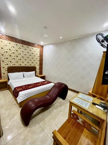 um quarto com uma cama com um repousa-pés de couro em 89 Motel em Hoàng Mai