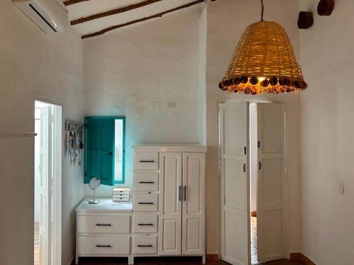 巴里查拉的住宿－Casa Castañeto Barichara，一间设有白色橱柜和吊灯的房间