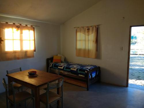 1 dormitorio con mesa, cama, mesa y sillas en Cabaña Siquiman in 