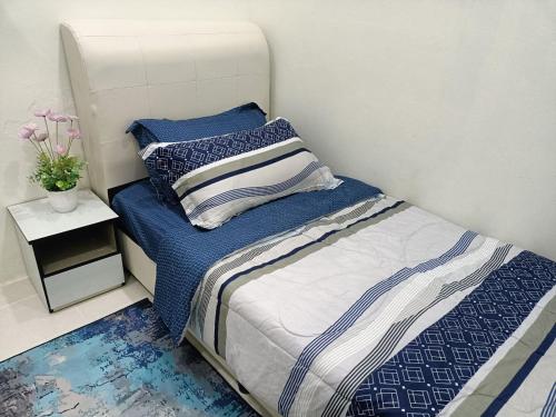 uma cama com lençóis azuis e brancos num quarto em Ceri Kluang Homestay (Corner Lot) em Keluang