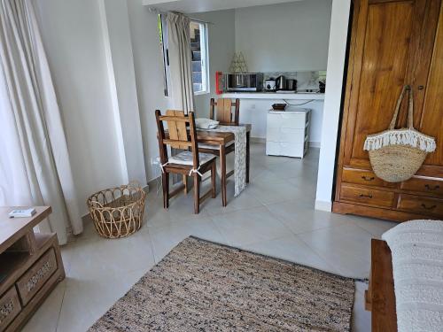 a living room with a table and chairs and a kitchen at SOUTH HILL VILLA in Mahe
