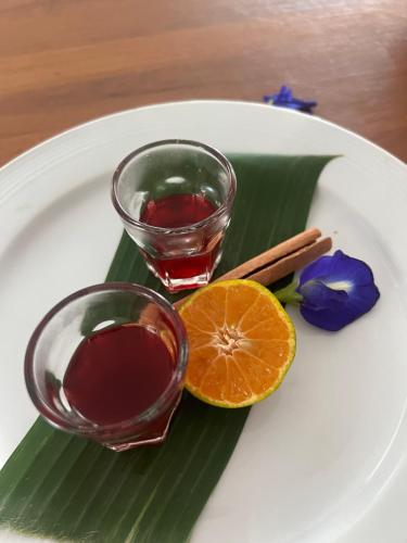 une assiette avec un verre et une tranche orange dans l'établissement ริมยมรีสอร์ท, à Ban Wang Din