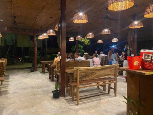 un grupo de personas sentadas en una mesa en un restaurante en Sok San Villa Koh Rong, en Phumĭ Kaôh Rŏng