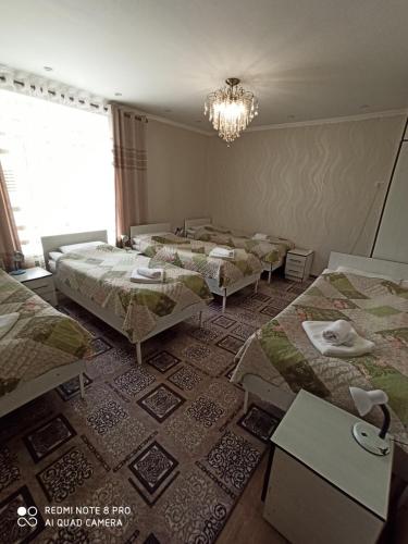卡拉科爾的住宿－Guest house Nuri，吊灯房间中的一组床位