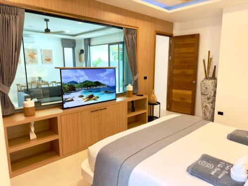 a bedroom with a bed and a flat screen tv at Yuka residence in Koh Samui 