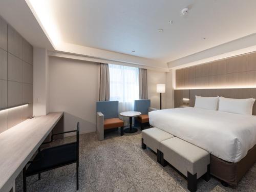 福岡市にあるHOTEL IL PALAZZO - Vacation STAY 68248vの大きなベッドとデスクが備わるホテルルームです。