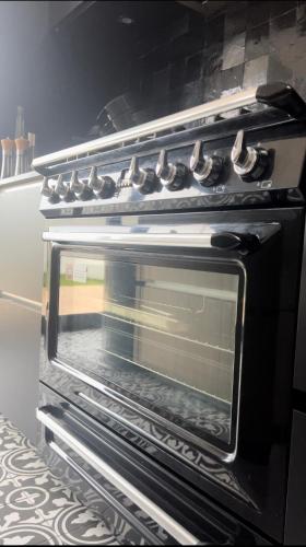 an oven with its door open in a kitchen at Appartement 3 chambres Centre Vilvoorde Bruxelles BrusselsAirport Expo NATO Anvers Wifi Free Parking in Vilvoorde
