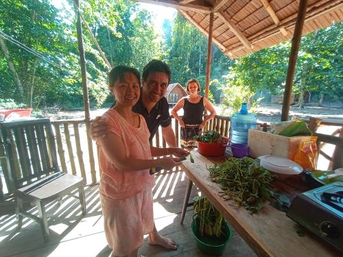 a man and a woman standing in front of a table at Tanjung Kalemo Resort in Batudaka