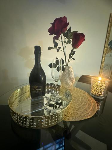 a bottle of wine sitting on a glass table with a candle at Le Plaisir Luxury Room con vasca idromassaggio in Martina Franca