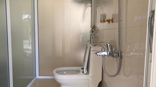 a bathroom with a toilet and a shower at Jabal shams domes in Sa‘ab Banī Khamīs