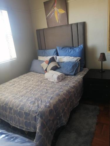 a bedroom with a large bed with blue pillows at Home away from home in Cape Town