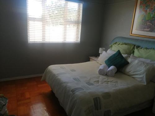 a bedroom with a bed with two pillows and a window at Home away from home in Cape Town