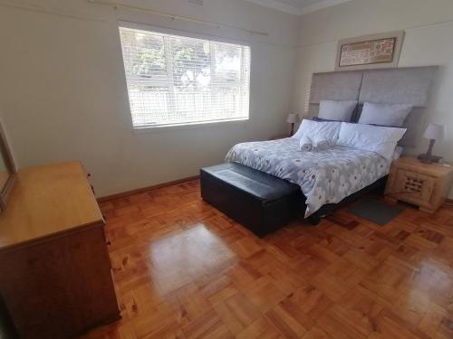 a bedroom with a bed and a wooden floor at Home away from home in Cape Town