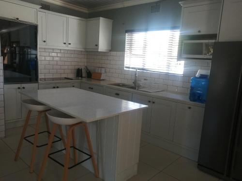 a kitchen with white cabinets and a white counter top at Home away from home in Cape Town