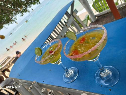 dos cócteles sentados en una mesa cerca de la playa en Hugos Place Baru en Cartagena de Indias