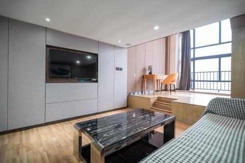 a living room with a couch and a tv at Lavendar Duplex Apartment in Guangzhou
