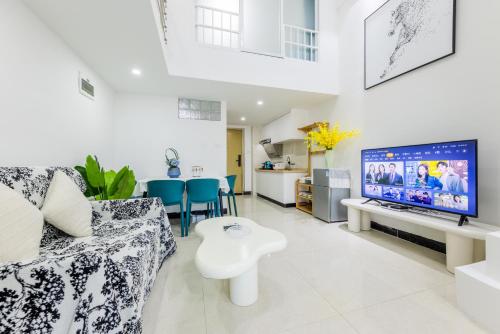 a living room with a couch and a tv at Lavendar Duplex Apartment in Guangzhou
