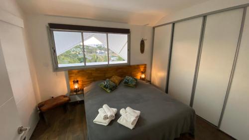 ein Schlafzimmer mit einem Bett mit zwei Handtüchern darauf in der Unterkunft Roof top dans les quartiers sud de Nouméa in Noumea