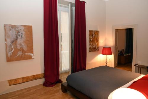 um quarto com uma cama com cortinas vermelhas e uma janela em Casa Cammarota em Nápoles