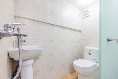 a bathroom with a toilet and a sink at Lavendar Duplex Apartment in Guangzhou