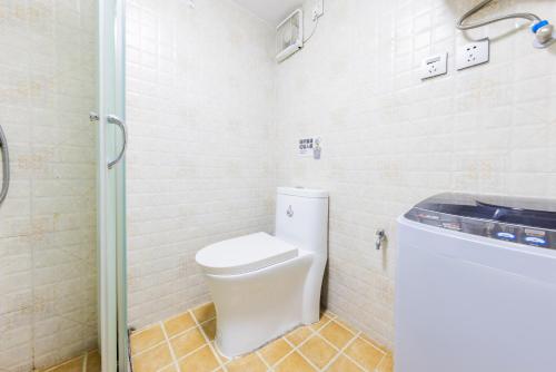 a bathroom with a toilet and a shower at Lavendar Duplex Apartment in Guangzhou