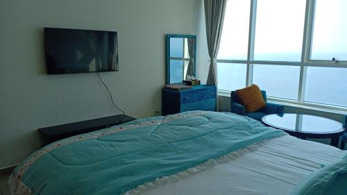 a bedroom with a bed and a tv and a table at FT22 R3 Open beach ajman washroom is outside in Ajman 