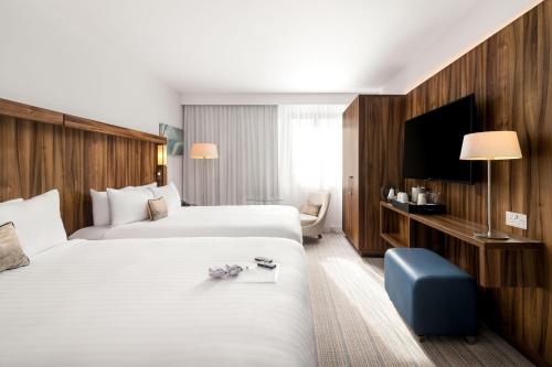 um quarto de hotel com duas camas e uma televisão em Courtyard by Marriott Glasgow Airport em Paisley