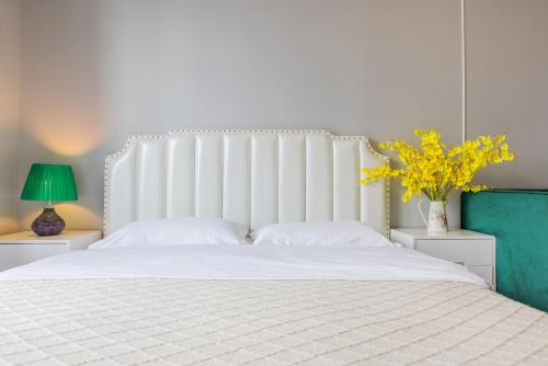 a bedroom with a large white bed with yellow flowers at Lavender Apartment in Guangzhou
