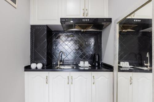 a kitchen with white cabinets and a black counter top at Lavender Apartment in Guangzhou