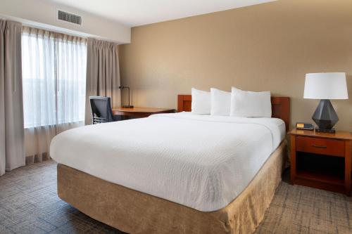 Habitación de hotel con cama grande y escritorio. en Residence Inn by Marriott Rogers, en Rogers