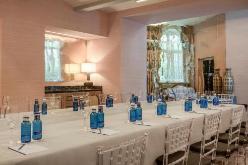 a room with a long table with blue bottles on it at Santo Mauro, a Luxury Collection Hotel, Madrid in Madrid