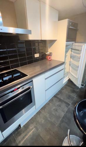 a kitchen with white cabinets and a stove at Appartement 3 chambres Centre Vilvoorde Bruxelles BrusselsAirport Expo NATO Anvers Wifi Free Parking in Vilvoorde