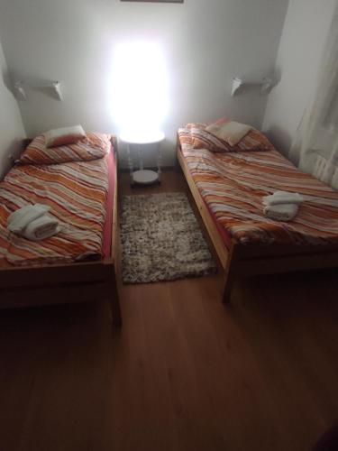 two twin beds in a small room with a window at Agroturystyka u Zosi in Żegiestów