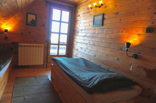 una camera con un letto su una parete in legno di Cozy chalet Montana a Kopaonik