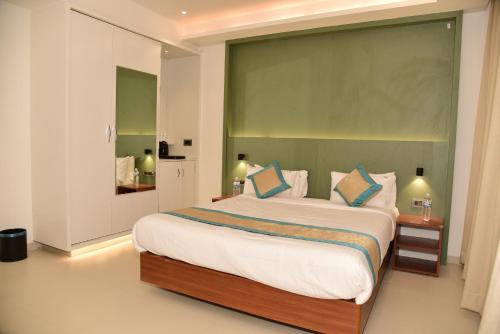 a bedroom with a large bed with blue pillows at Hotel Sai Krishna in Shirdi