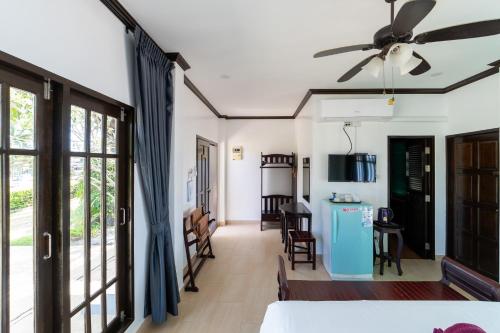 Habitación con cama y ventilador de techo. en Baan Faa Talaychan Resort, en Chao Lao Beach