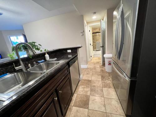 a kitchen with a sink and a refrigerator at Venetian La Jolla One bedroom condo luxury furnished near beach and UTC mall in San Diego