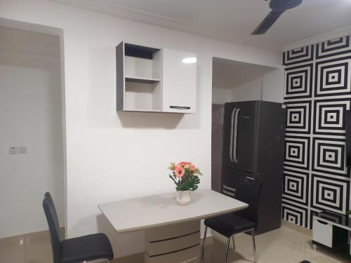 uma cozinha com uma mesa branca e um frigorífico preto em KESEWAA's APARTMENT em Acra