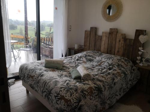 a bedroom with a bed and a view of a balcony at Gites Mendiburia in Iholdy