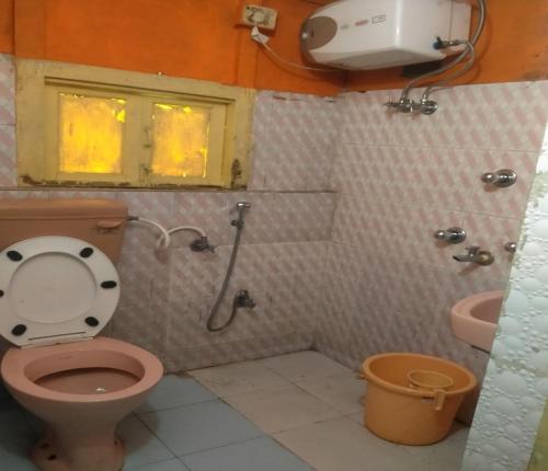 a bathroom with a pink toilet and a sink at Karma Homestay by StayApart in Aritar