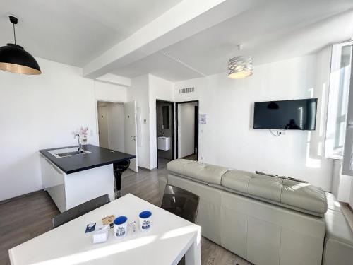 a living room with a couch and a table at Brand new 2 BR Gambetta Fully Renovated 2021- 5 mns Palais by Olam Properties in Cannes